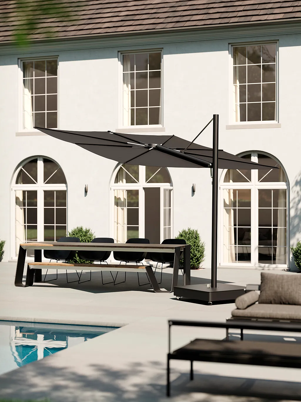 Schwarzer Sensu Sonnenschirm beschattet einen Esstisch auf einer Poolterrasse neben einer weißen Villa.