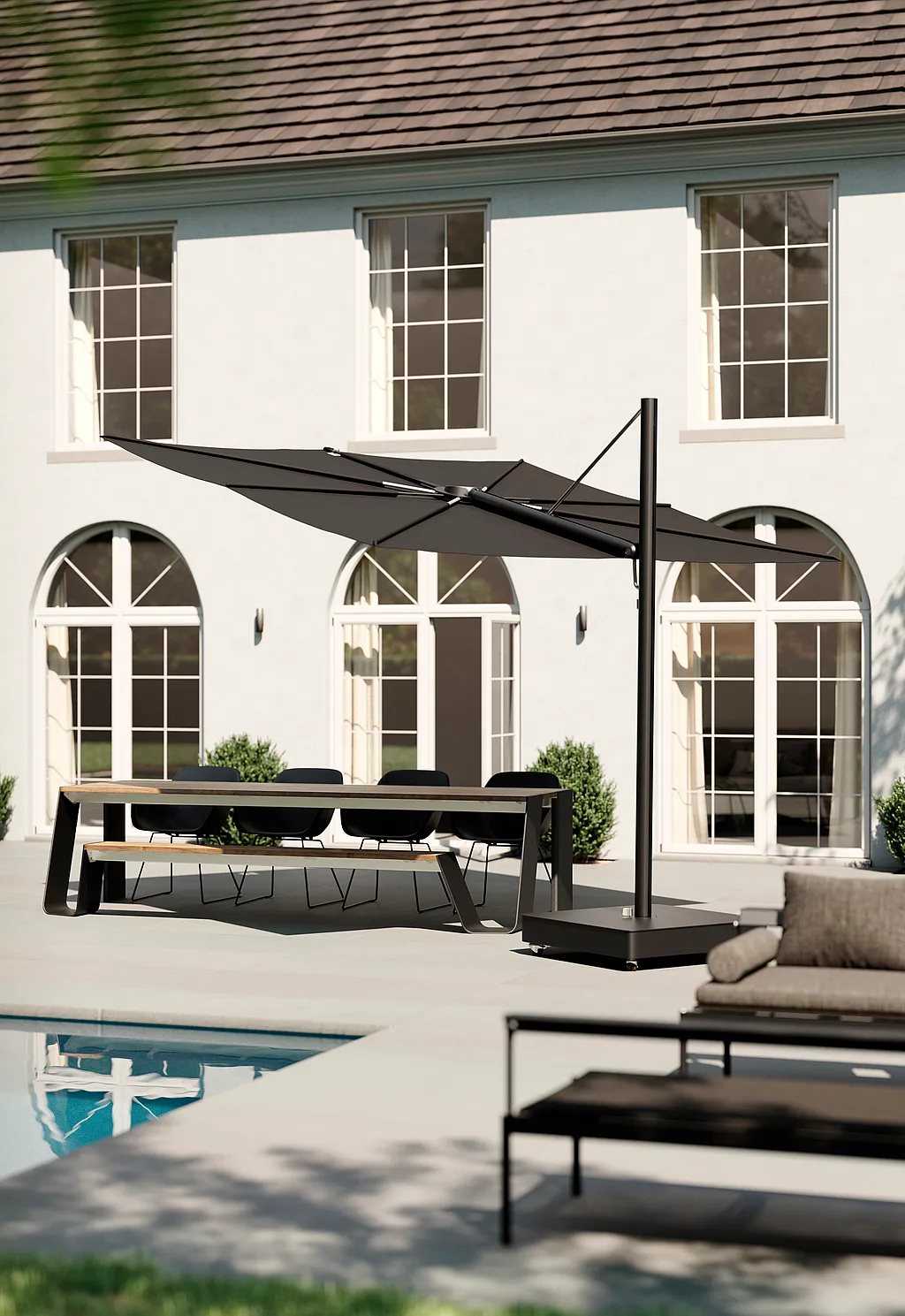Schwarzer Sensu Sonnenschirm beschattet einen Esstisch auf einer Poolterrasse neben einer weißen Villa.