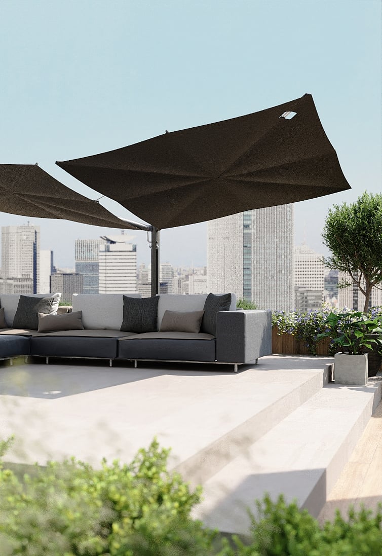 Black Sensu shade above a grey Walrus outdoor sofa on a rooftop terrace with plants and a city skyline in the background.