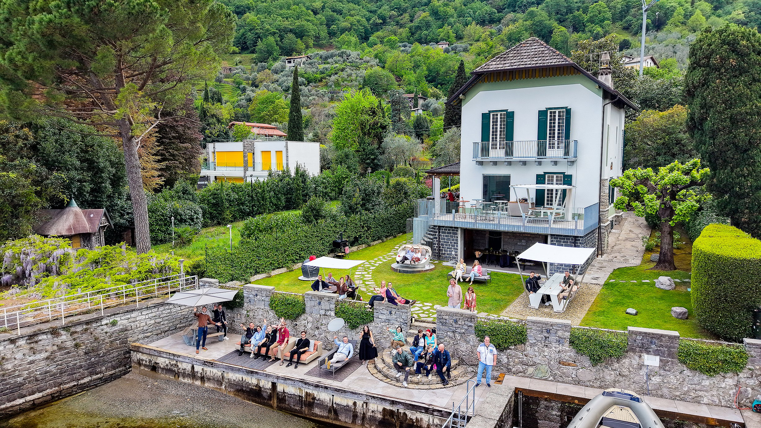 Aerial view of a lakeside villa in Vassena on Lake Como with Extremis outdoor furniture on the waterfront terrace
