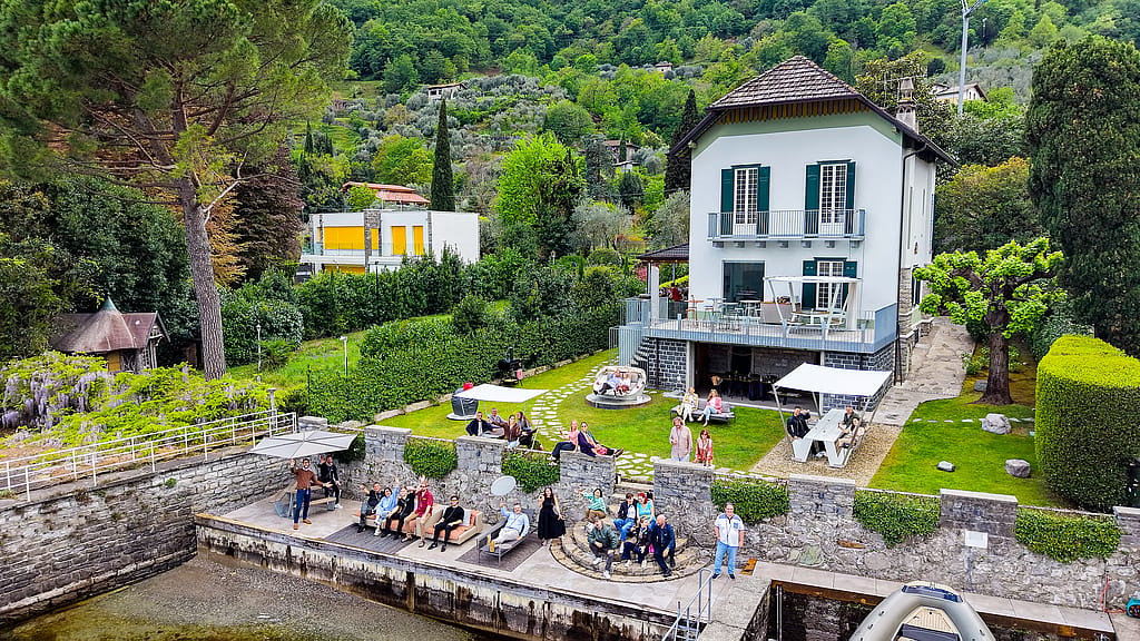 Aerial view of a lakeside villa in Vassena on Lake Como with Extremis outdoor furniture on the waterfront terrace