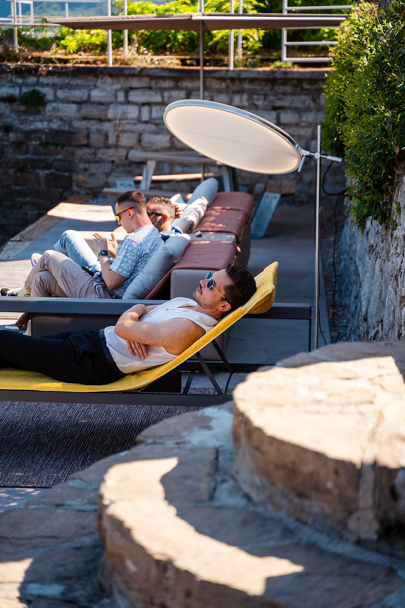 Guests stretched out on the Extremis Sol+Luna sunbed at the water's edge