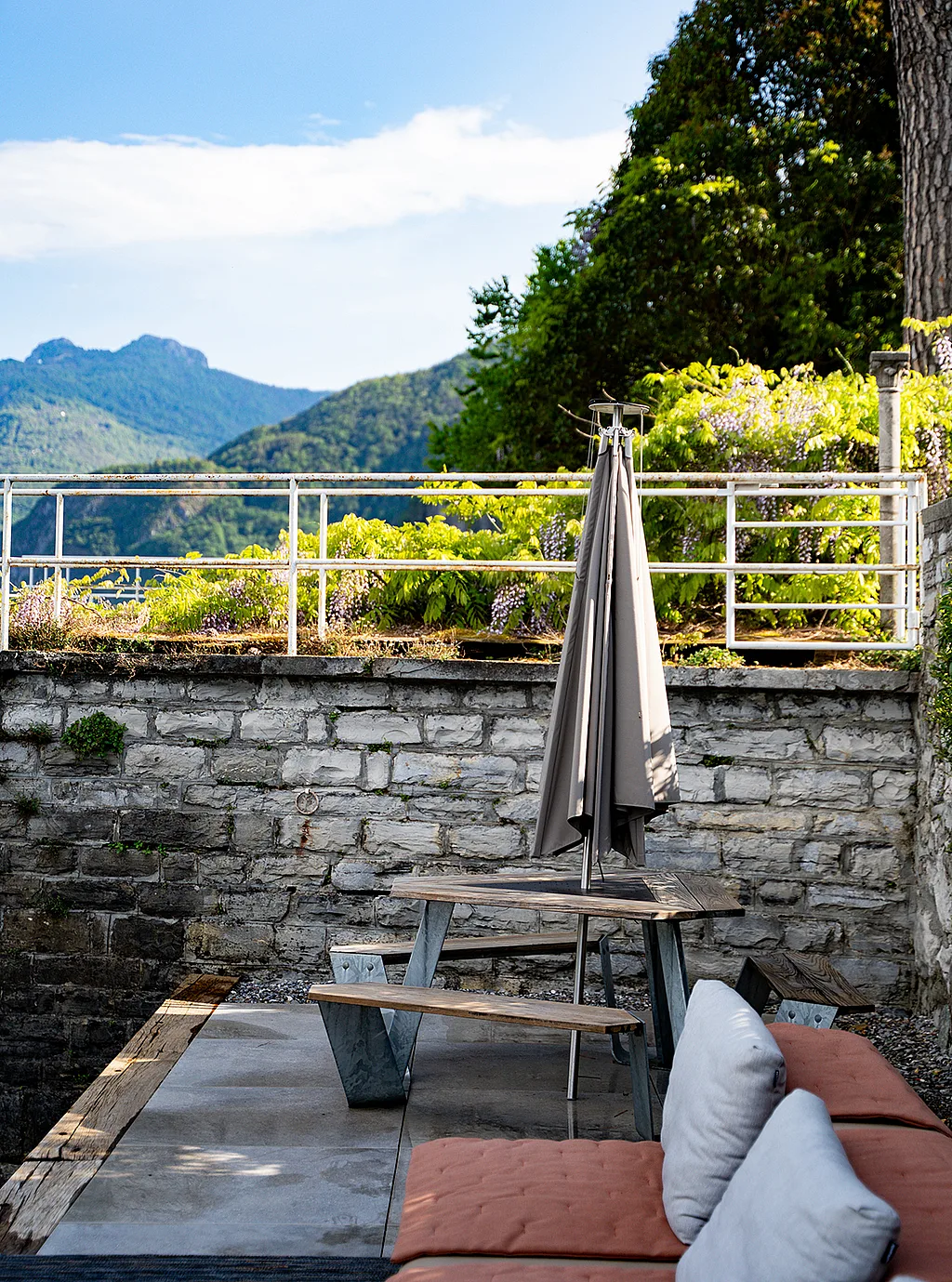 Extremis Anker picnic table with a closed Inumbrina shade on a terrace overlooking Lake Como