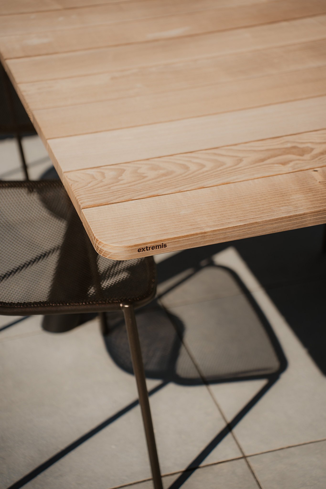 Close-up of the wooden table top of the Extremis Panigiri outdoor dining table
