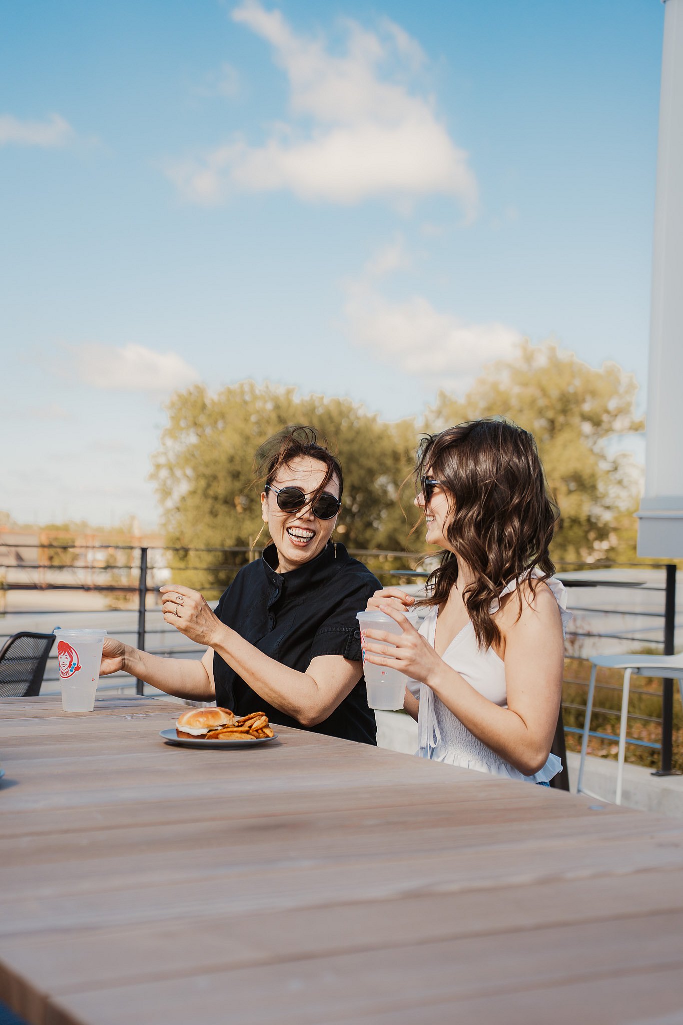 Two guests toasting at an Extremis Panigiri outdoor dining table on the terrace