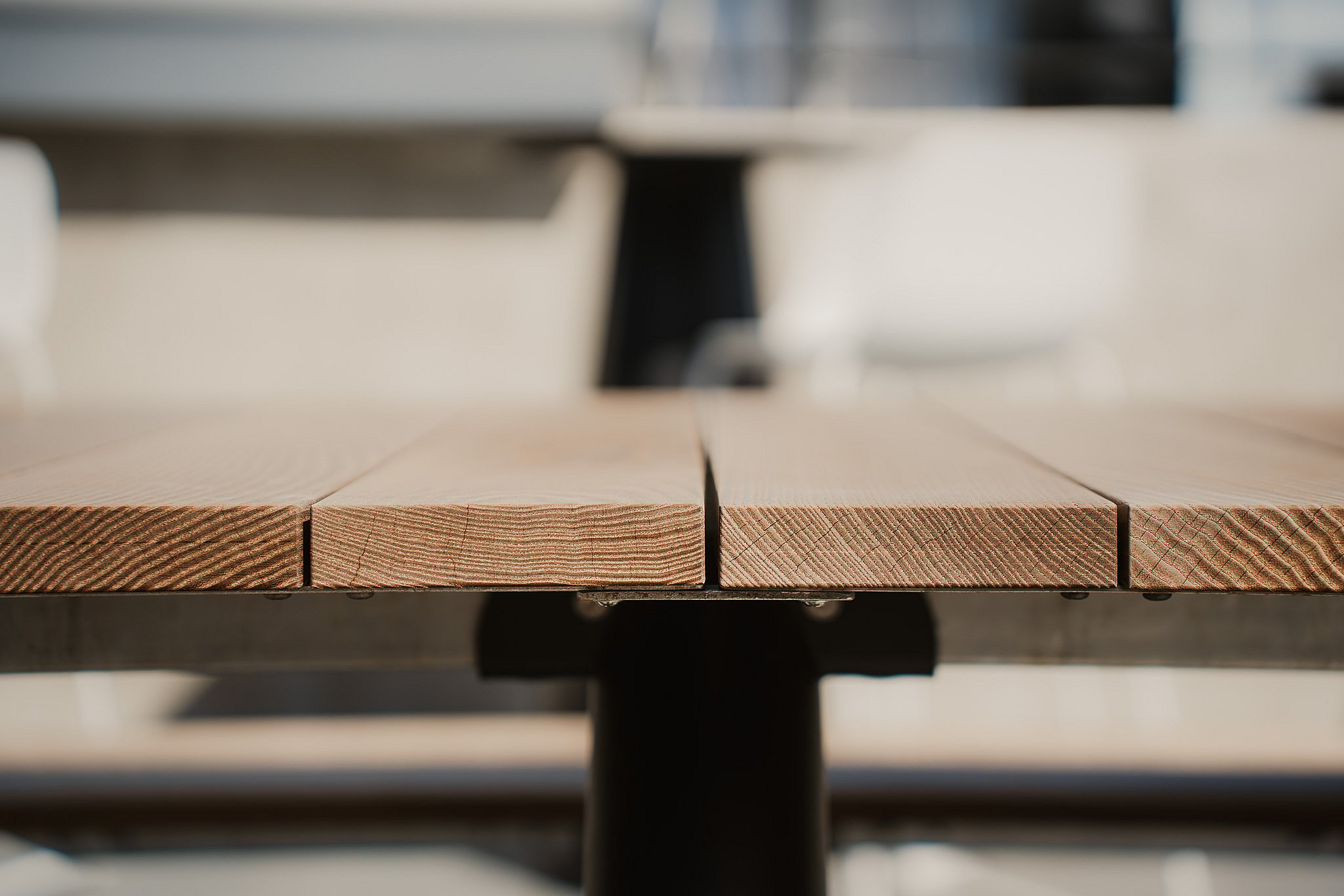Detail of the frame and wooden top of the Extremis Panigiri outdoor dining table