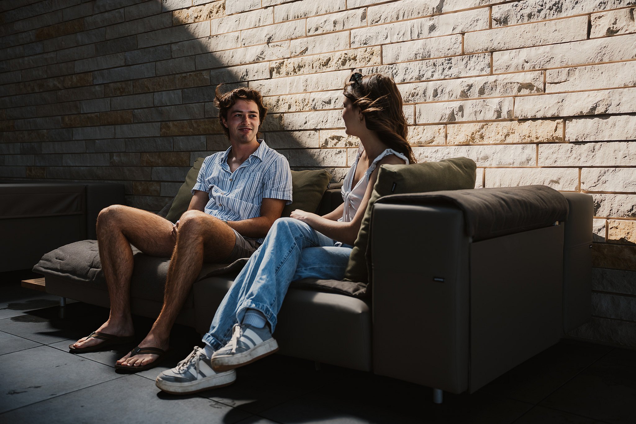 Two guests side by side on an Extremis Walrus outdoor sofa on the Club Terrace