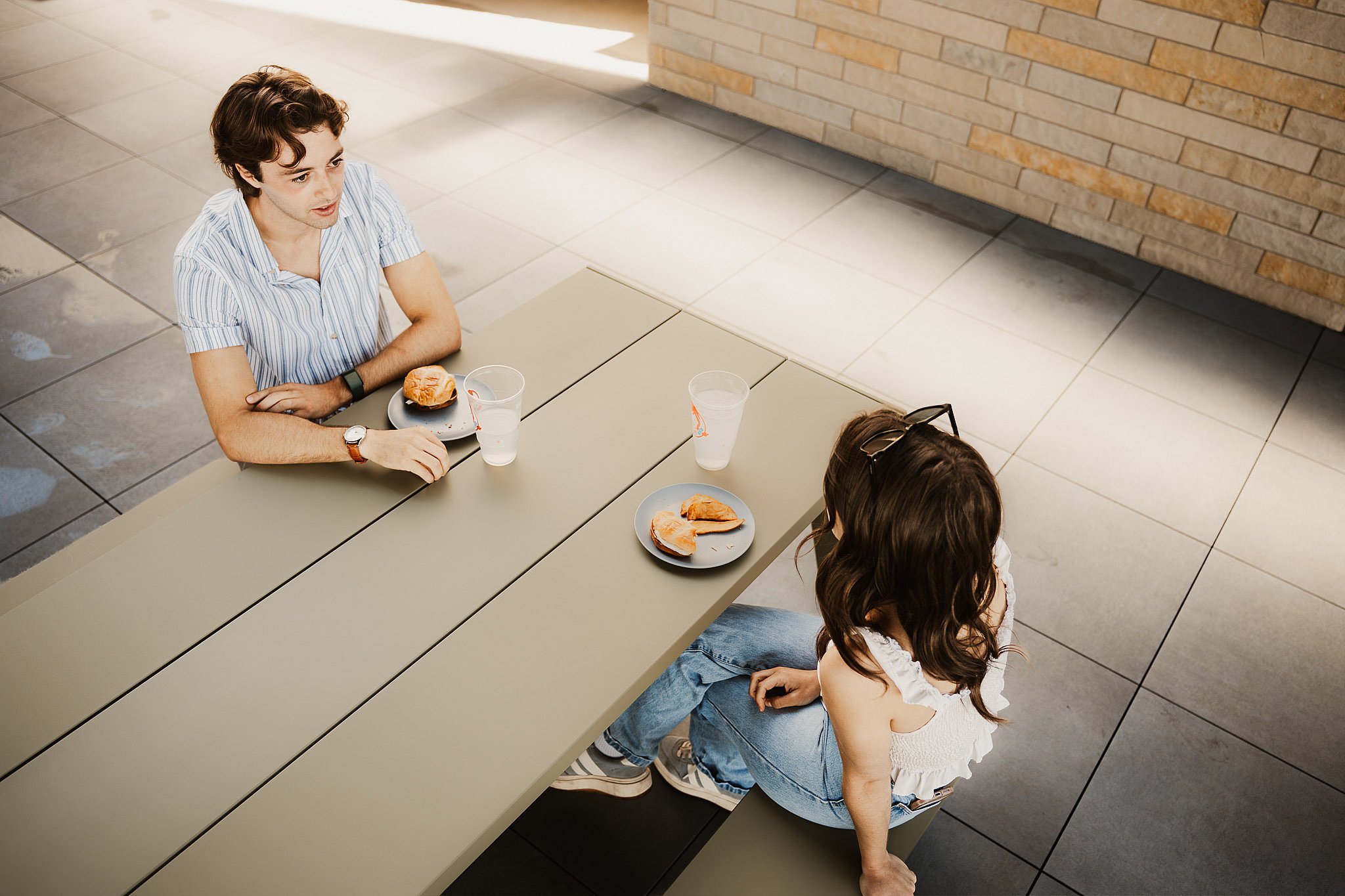 Two guests eating at an Extremis Hopper aluminum picnic table on the Club Terrace
